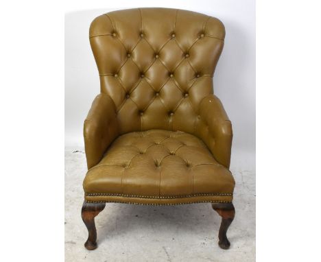 A reproduction leather upholstered button back armchair raised on cabriole legs, height 86cm, depth 57cm, width 58cm.Addition