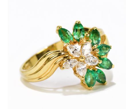 A contemporary 14ct yellow gold diamond and emerald ring of swept design set with five marquise cut diamonds and six marquise