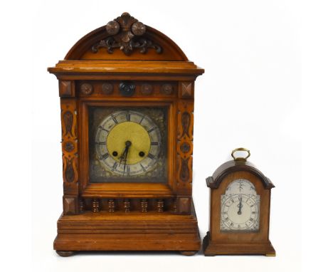 A late 19th century walnut mantel clock with carved decoration surrounding the brass base with applied silvered chapter ring 