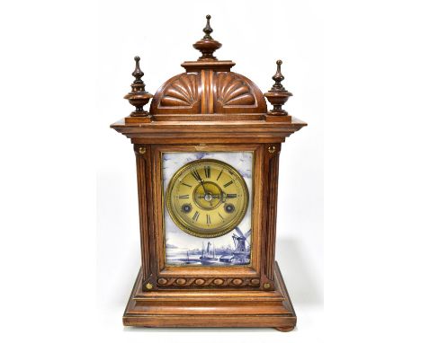 A late 19th century walnut mantel clock with circular dial set with Roman numerals within a framed tile surround, height 41.5
