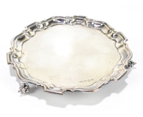 VINERS; a George V hallmarked silver waiter the cast scalloped edge raised on three scrolling feet, Sheffield 1935, approx 10