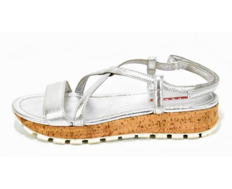 PRADA; a pair of LR Lea silver leather strappy sandals with cork platform heel and front toe strap, with maker’s logo to top 