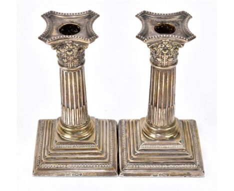 HARRISON BROTHERS &amp; HOWSON; a pair of Victorian hallmarked silver Corinthian column squat candlesticks, Sheffield 1891, h