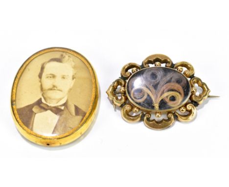 A 19th century yellow metal mourning brooch of pierced oval form with central plaited section of hair, width 50mm, and a furt