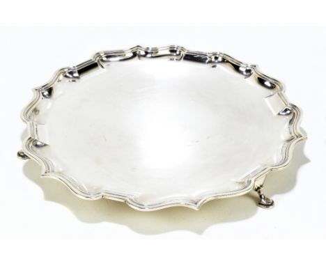ELKINGTON &amp; CO; a George V hallmarked silver salver with cast piecrust edge, raised on three hoof feet, Birmingham 1927, 