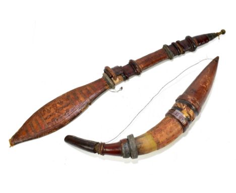 A tribal machete type knife with leather and brass mounted handle and decorated paddle shaped leather scabbard, length 76cm, 