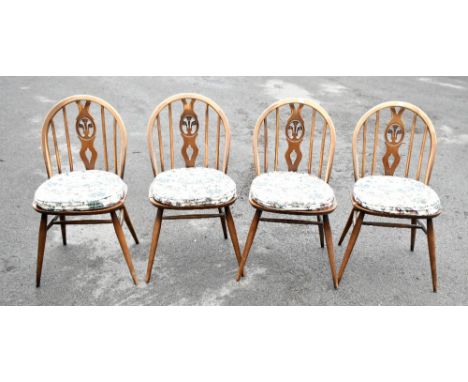 ERCOL; a set of four Windsor type dining chairs with pierced splat backs, on spindle supports (4).