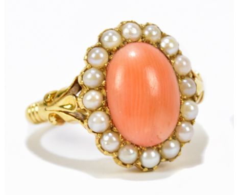 A Victorian 18ct yellow gold, coral and pearl ring, the oval coral cabochon set within a border of pearls with fleur-de-lis d