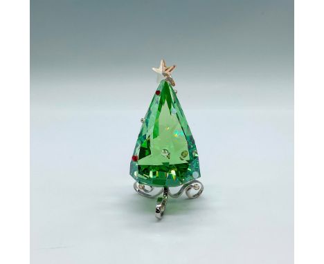 A whimsical small Christmas tree in a peridot crystal with red, clear, and white crystal accents. A light golden crystal star