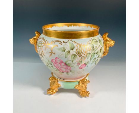 An exquisite planter in white, pink, and green tones adorned with gold lion head handles, elegantly positioned opposite each 