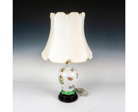 Beautiful porcelain lamp featuring hand painted bouquets of flowers that are surrounded by colorful butterflies on a textured