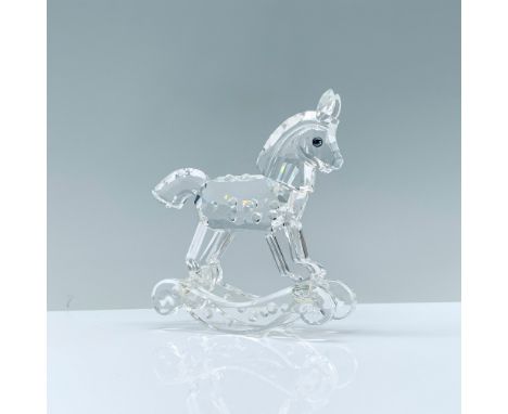 A clear crystal figurine of a toy rocking horse that has raised crystal points and cerulean-colored eyes. Swarovski backstamp