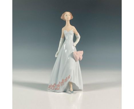 Glossy finish figure of a lady wearing a striking strapless gown in mid pose. Lladro backstamp. This item has its original bo