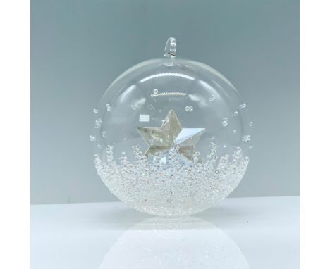 A clear crystal Christmas ball ornament adorned with dazzling crystals that contains a star in its center and a rhodium tag e