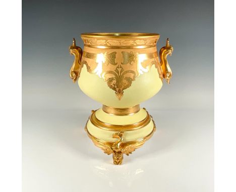 An exquisite planter in yellow and gold tones adorned with a pair of gilded scrolled handles, elegantly positioned opposite e