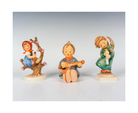 In the enchanting trio of Hummel pieces, Apple Tree Girl depicts a young girl nestled on top of the branches of a flourishing