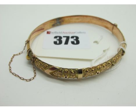 A 9ct Gold Bangle, texture decorated to the front, hinged to snap clasp (internal diameter 5.8cm).