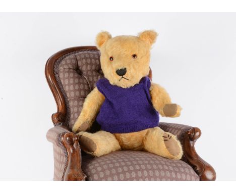 A Chiltern  post-war teddy bear, with orange and black glass eyes, swivel head, jointed limbs and cloth pads, in a purple tan