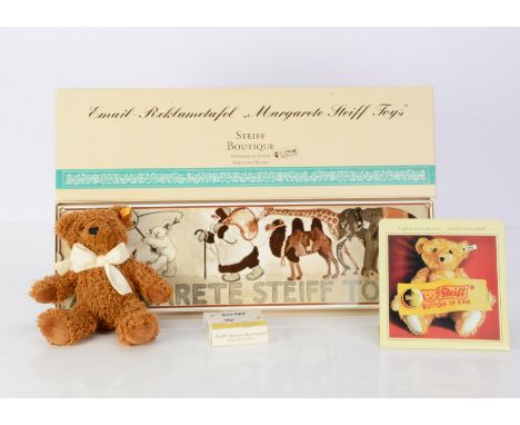 A Steiff enamel Margarete Steiff Toys wall plaque,  in original box, a set of playing card, unjointed yellow tag teddy bear a