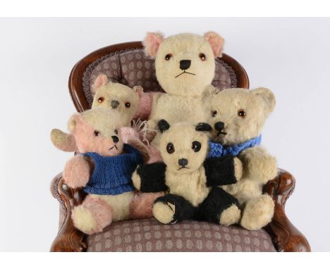 Five unjointed Post-war British teddy bears,  one with pink and white mohair, a panda with remains of label to foot and anoth