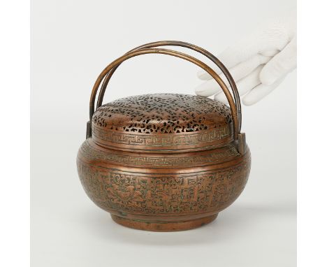 19th century Chinese Qing dynasty copper handwarmer or footwarmer. A round form with an intricately piercing lid and two hand