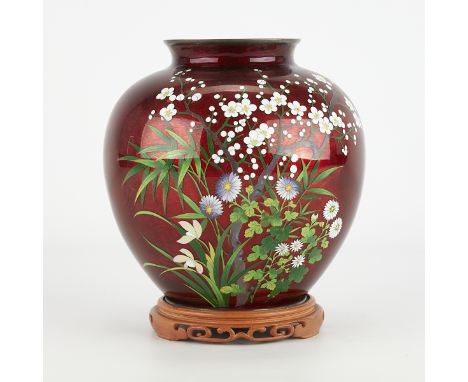 Japanese pigeon blood red cloisonne vase depicting a spray of blooming flowers. With a pierced and carved wooden stand. Stamp