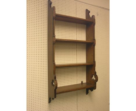 A Victorian Gothic Revival oak shelf unit, four fitted shelves, each end fronted with columns and pierced with a cusped trefo