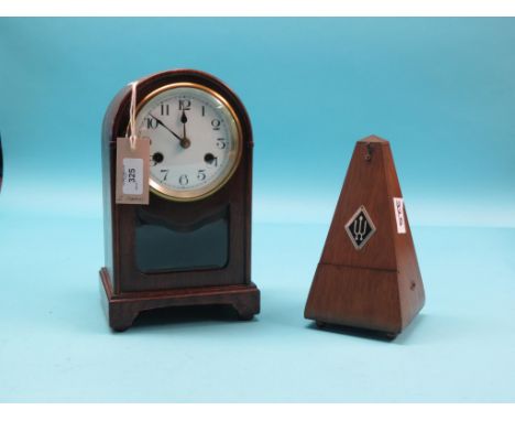 An oak mantel clock, with enamelled dial, with key and pendulum, 11.5in., and an oak cased metronome 