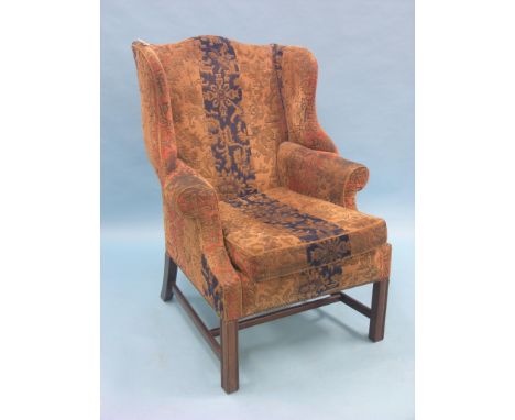A Chippendale-style mahogany wing armchair, upholstered in a multi-coloured stamped dralon, arm upholstery worn