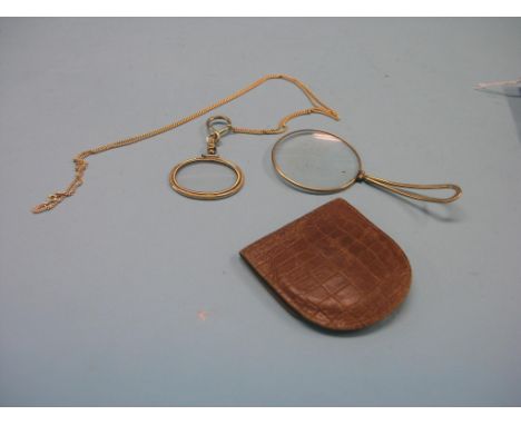 A gold plated lorgnette, on 9ct. gold chain, chain 7.2 grams, and a yellow metal magnifying glass with folding clip, each in 