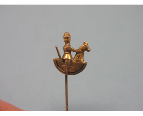 An unusual 9ct. gold stick-pin, finial in the form of a gentleman riding rocking horse