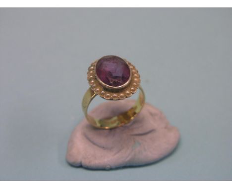 A gold dress ring, set large central amethyst and surrounding seed-pearls, size Q