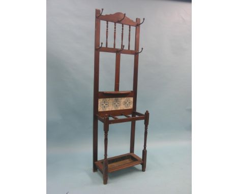 A Victorian mahogany hall stand, fitted with iron coat-hooks, printed ceramic tiles and umbrella stand with drip-tray, 1ft. 1