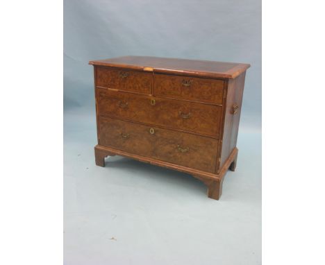 An early Georgian burr walnut chest, quarter-veneered and cross-banded top with herringbone inlay, two short and two long dra