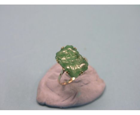 A 9ct. gold jade ring, rectangular jade carved with lotus, size O