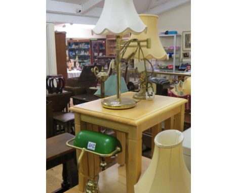 A brass desk lamp, with adjustable green glass shade, three other brass table lamps and a brass floor lamp, all with shades, 