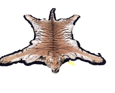 Tiger skin rug with taxidermied head, with glass eyes and realistic teeth, see photos for condition (there is wear and losses