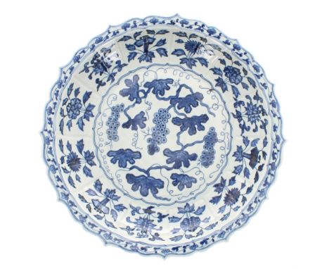 Chinese blue and white porcelain circular shallow charger, painted with grapes within a moulded raised foliate border and sha