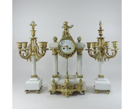 A continental white marble and gilt metal mounted three piece clock garniture, the portico clock, having a white enamel dial,