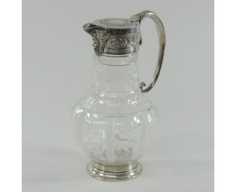 A Victorian silver mounted glass claret jug, having a floral relief decorated spout, above an intaglio decorated baluster sha