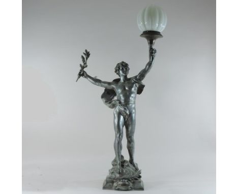 An early 20th century French figural silvered metal table lamp, in the form of a male nude holding aloft a torch, on a scroll