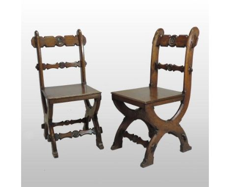 A pair of 19th century carved light oak hall chairs, in the manner of A.W.N. Pugin, each with a solid seat on an x frame base