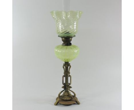An Arts and Crafts brass oil lamp, with a green opaline glass shade, 71cm high