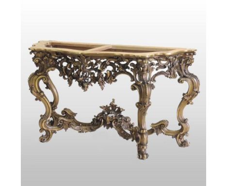 An ornate 19th century Italian carved and gilt wood console table base, of serpentine form, decorated throughout with scrolli
