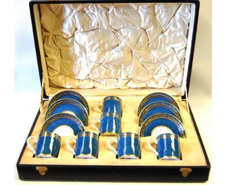 Set of six Fenton blue and gilt coffee cans and saucers, cased.