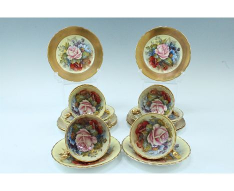 A set of six Aynsley teacups, saucers and side plates, gilt exteriors and decorated with roses by Joseph A. Bailey (active 19