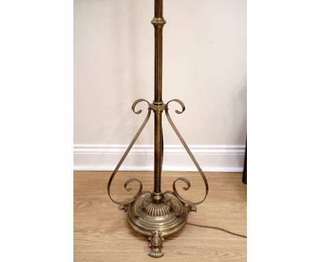 An Edwardian brass telescopic brass oil lamp stand, later converted to electricity, having a circular column with scrolling s