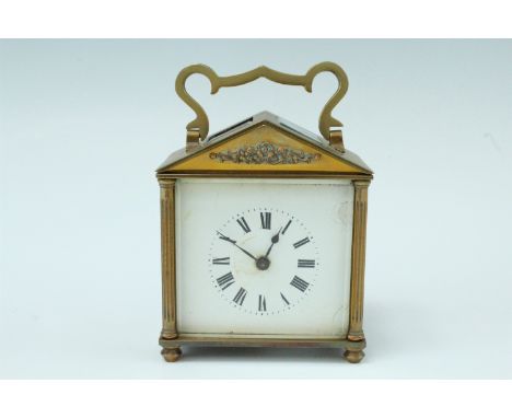An early 20th Century brass carriage clock, key wind and set, having an architectural case with fluted columns, a pediment an