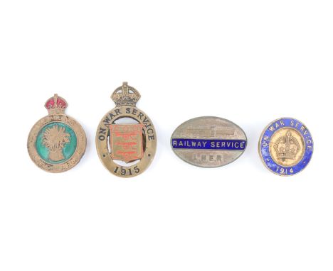 A Women's Land Army cap badge together with a variant enamelled 1915 "On War Service" lapel badge, one other, similar and an 