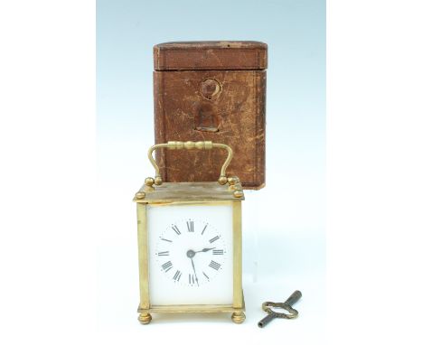 An early 20th Century leather cased brass carriage clock, the clock having brass sides and back, in a claret coloured travel 